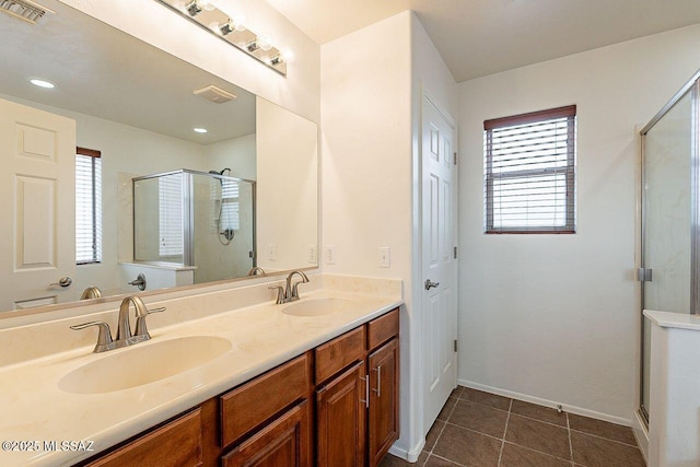 bathroom with vanity, walk in shower, a wealth of natural light, and tile patterned floors