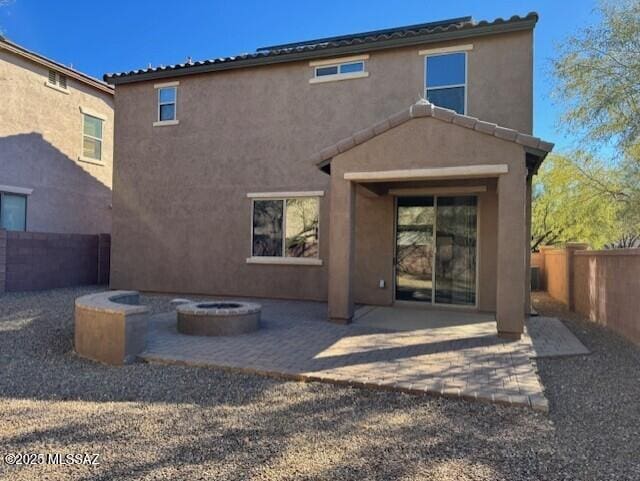 back of house with an outdoor fire pit and a patio area