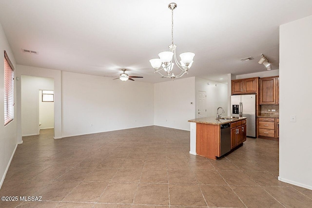 kitchen with decorative light fixtures, sink, tasteful backsplash, light stone counters, and appliances with stainless steel finishes