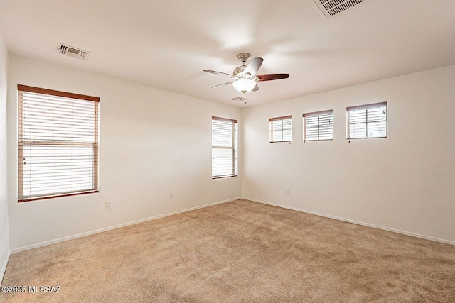 carpeted spare room featuring ceiling fan