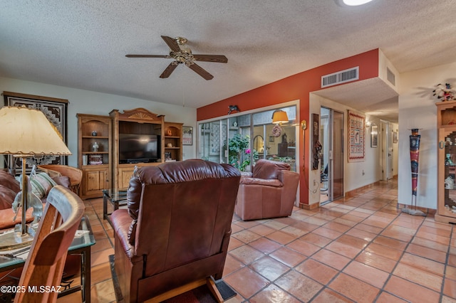 living room featuring light tile patterned flooring, a textured ceiling, and ceiling fan