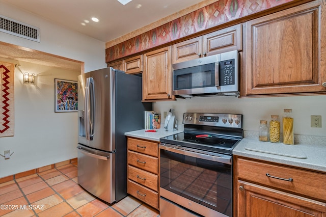 kitchen featuring stainless steel appliances and light tile patterned flooring