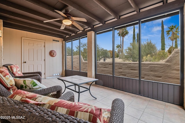 sunroom featuring beam ceiling and ceiling fan