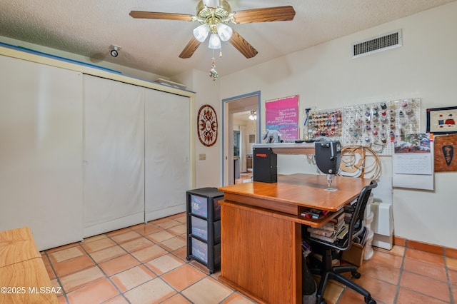 office space featuring light tile patterned floors, a textured ceiling, and ceiling fan