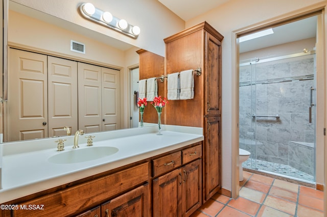 bathroom with vanity, tile patterned floors, a shower with door, and toilet