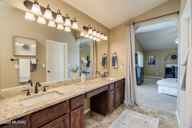 1943 W Desert Highlands Dr, Oro Valley, AZ 85737 - bathroom with vaulted ceiling, connected bathroom, double vanity, ceiling fan, and baseboards