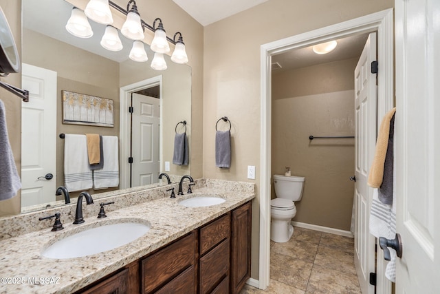 1943 W Desert Highlands Dr, Oro Valley, AZ 85737 - bathroom featuring double vanity, toilet, and baseboards
