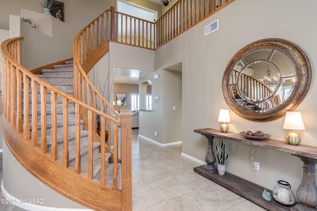 1943 W Desert Highlands Dr, Oro Valley, AZ 85737 - stairs with a chandelier, baseboards, arched walkways, and a high ceiling