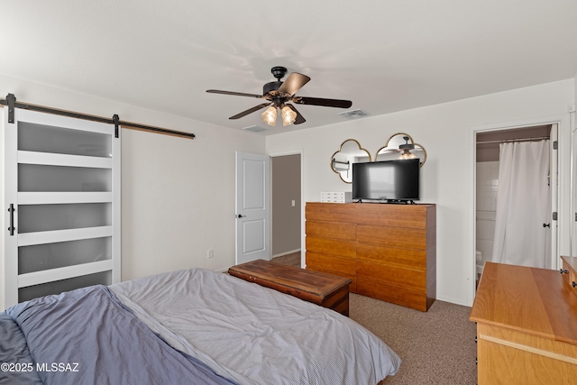 carpeted bedroom featuring a barn door and ceiling fan