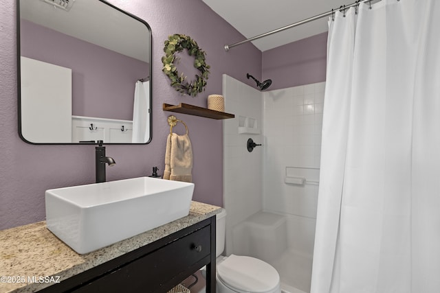 bathroom featuring vanity, toilet, and walk in shower