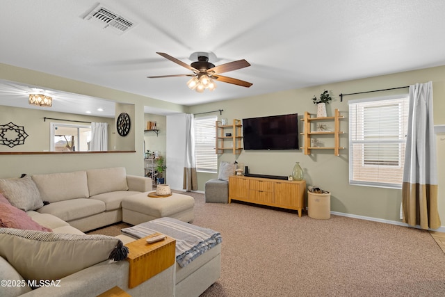 carpeted living room featuring ceiling fan, plenty of natural light, and a textured ceiling