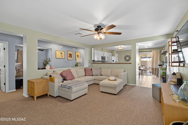 carpeted living room with ceiling fan