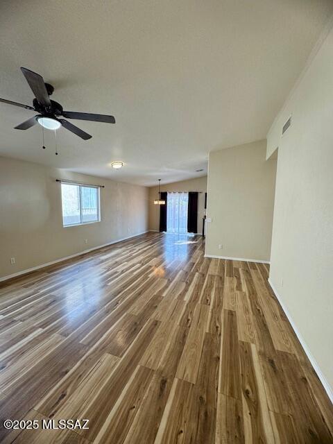 unfurnished living room with ceiling fan and hardwood / wood-style floors