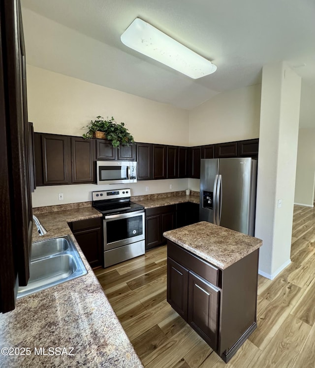 kitchen featuring appliances with stainless steel finishes, sink, dark brown cabinetry, and light hardwood / wood-style floors