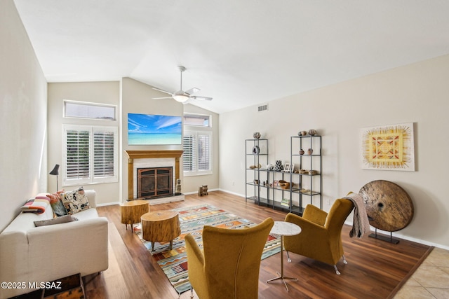 living room featuring wood-type flooring, ceiling fan, and vaulted ceiling