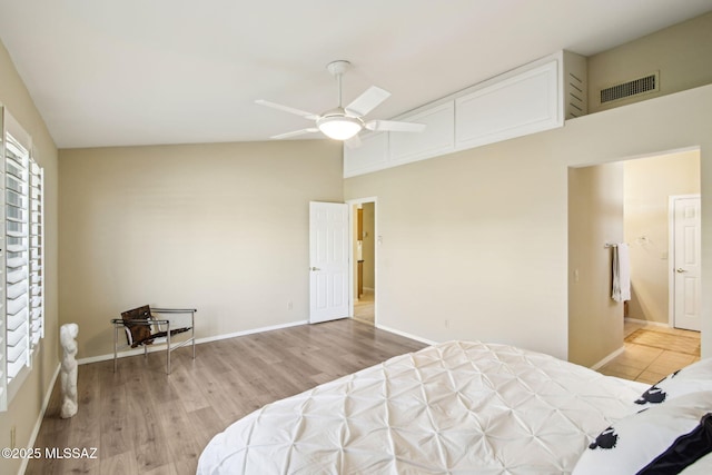 bedroom featuring light hardwood / wood-style flooring, ceiling fan, and a high ceiling