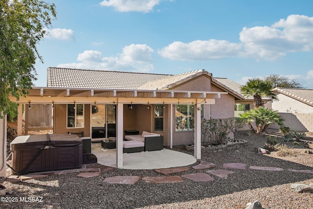 back of property with a hot tub and a patio