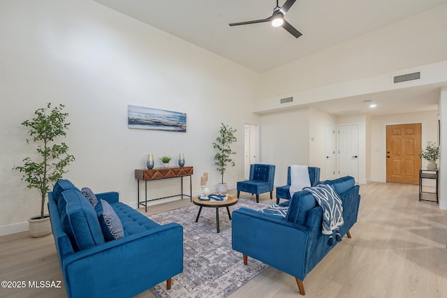 living room featuring ceiling fan, high vaulted ceiling, and light wood-type flooring