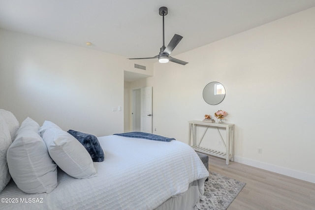 bedroom with ceiling fan, vaulted ceiling, and light hardwood / wood-style floors