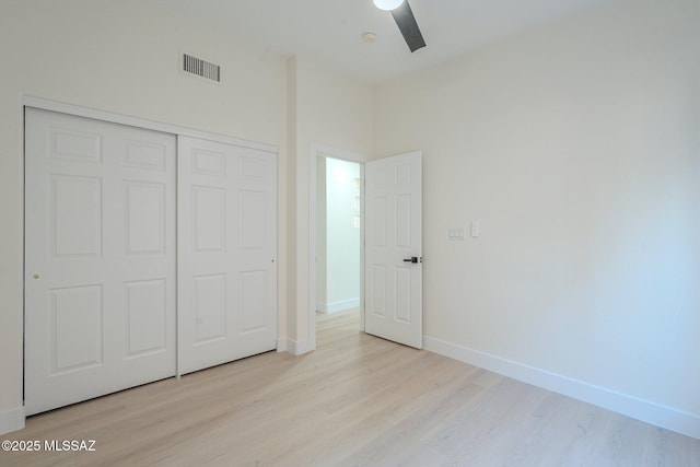 unfurnished bedroom featuring ceiling fan, light hardwood / wood-style floors, and a closet