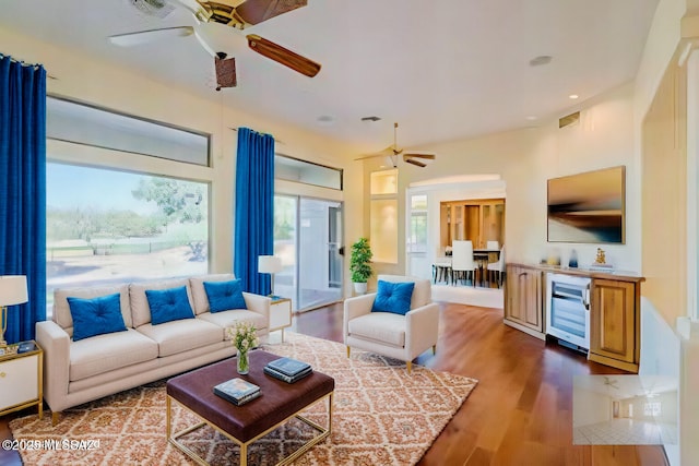 living room with wine cooler, wood-type flooring, and ceiling fan