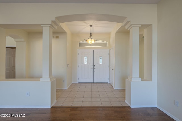 entryway featuring light hardwood / wood-style floors and ornate columns