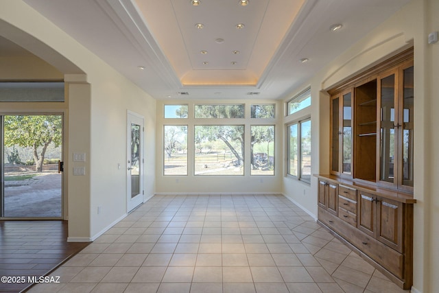 unfurnished sunroom featuring a raised ceiling