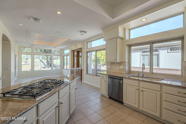 kitchen featuring sink, stainless steel gas cooktop, black dishwasher, a raised ceiling, and decorative backsplash