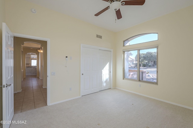 unfurnished bedroom featuring light colored carpet, a closet, and ceiling fan