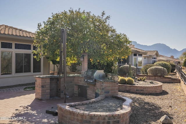 view of patio / terrace featuring an outdoor kitchen, a grill, and a mountain view