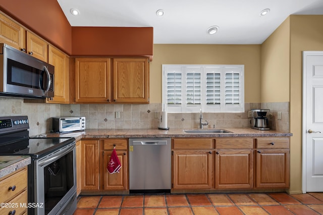 kitchen with appliances with stainless steel finishes, sink, and decorative backsplash