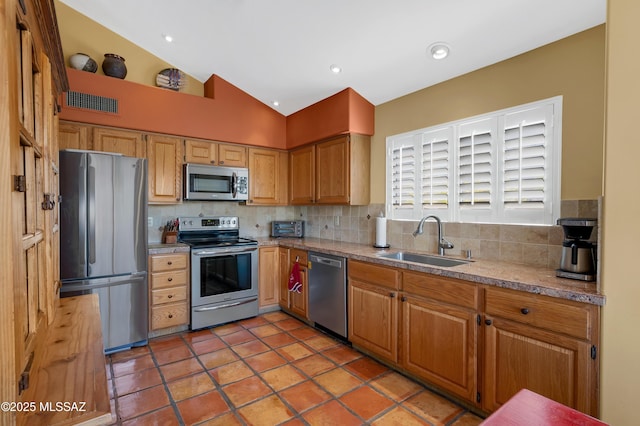 kitchen with stainless steel appliances, vaulted ceiling, sink, and decorative backsplash