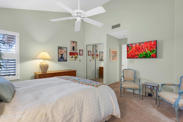 bedroom with ceiling fan, carpet flooring, a closet, and a high ceiling