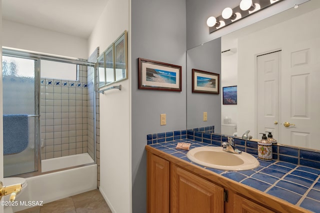 bathroom featuring vanity, bath / shower combo with glass door, and tile patterned flooring