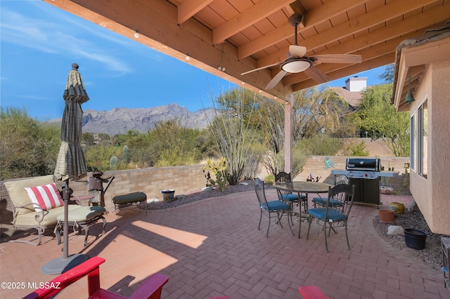 view of patio / terrace featuring ceiling fan, grilling area, and a mountain view