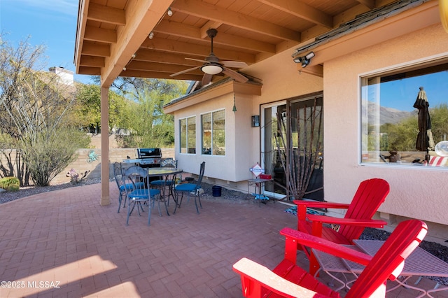 view of patio featuring area for grilling, a mountain view, and ceiling fan