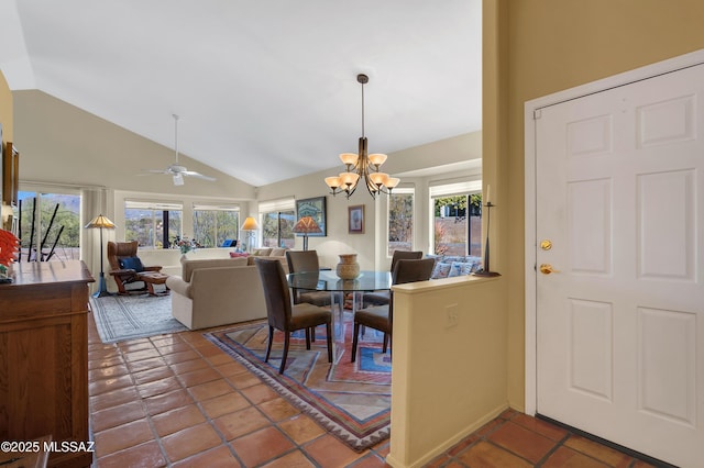 dining space featuring ceiling fan with notable chandelier and high vaulted ceiling