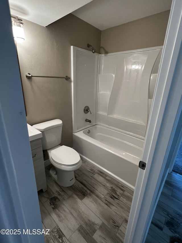 full bathroom featuring vanity, hardwood / wood-style floors, shower / bathtub combination, and toilet