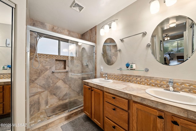 bathroom featuring vanity, decorative backsplash, and a shower with door