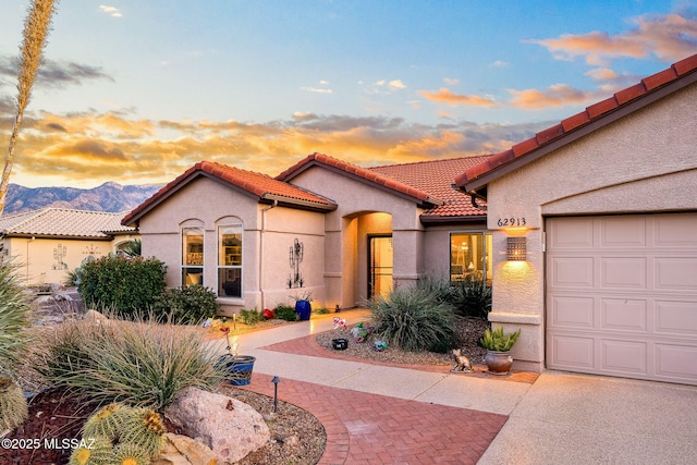 mediterranean / spanish-style house with a garage and a mountain view