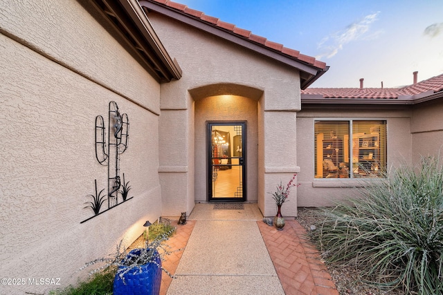 exterior entry at dusk with a patio area