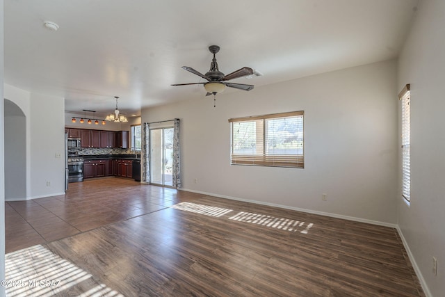 unfurnished living room featuring dark hardwood / wood-style floors and ceiling fan with notable chandelier