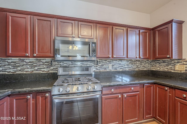 kitchen with stainless steel appliances, dark stone countertops, and backsplash