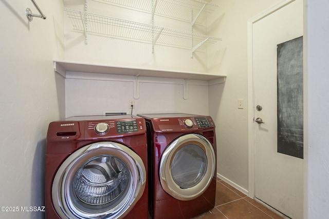 washroom with dark tile patterned flooring and washer and clothes dryer