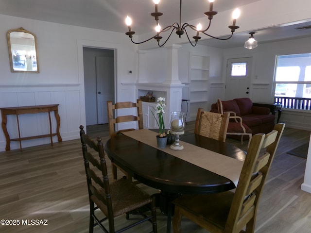 dining area featuring hardwood / wood-style flooring and ornate columns