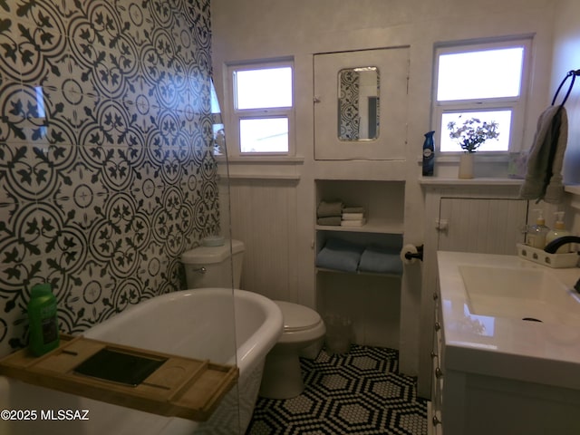 bathroom with vanity, a tub, tile patterned floors, and toilet