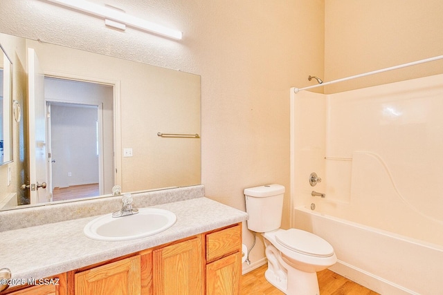 bathroom featuring vanity, shower / tub combination, toilet, and wood finished floors