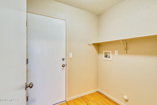 washroom with light wood-style flooring, baseboards, hookup for a washing machine, and laundry area