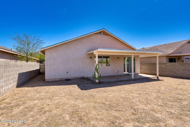 rear view of property with a patio area, a fenced backyard, and stucco siding