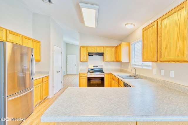 kitchen with under cabinet range hood, light countertops, vaulted ceiling, appliances with stainless steel finishes, and a sink